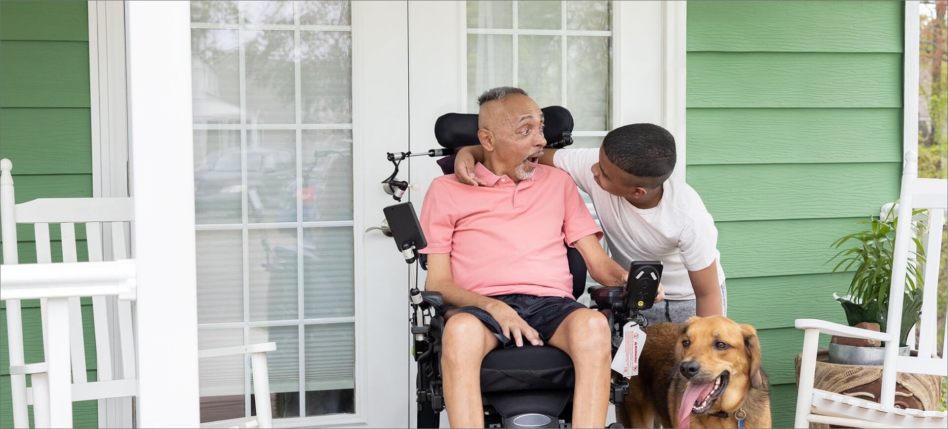 ALS patient in motorized chair with family member and dog