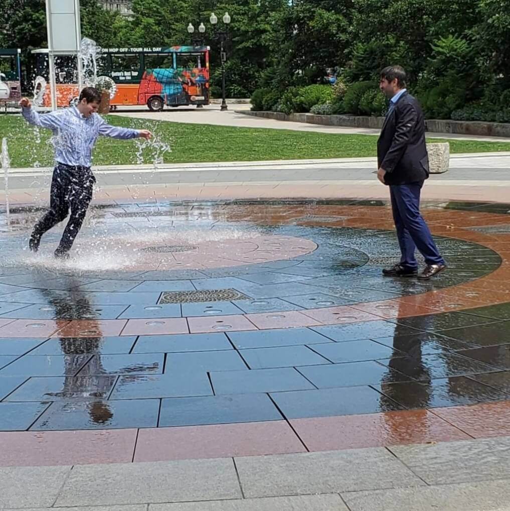 CEO Soak - Josh Cohen and Justin Klee standing in water fountain wearing suits