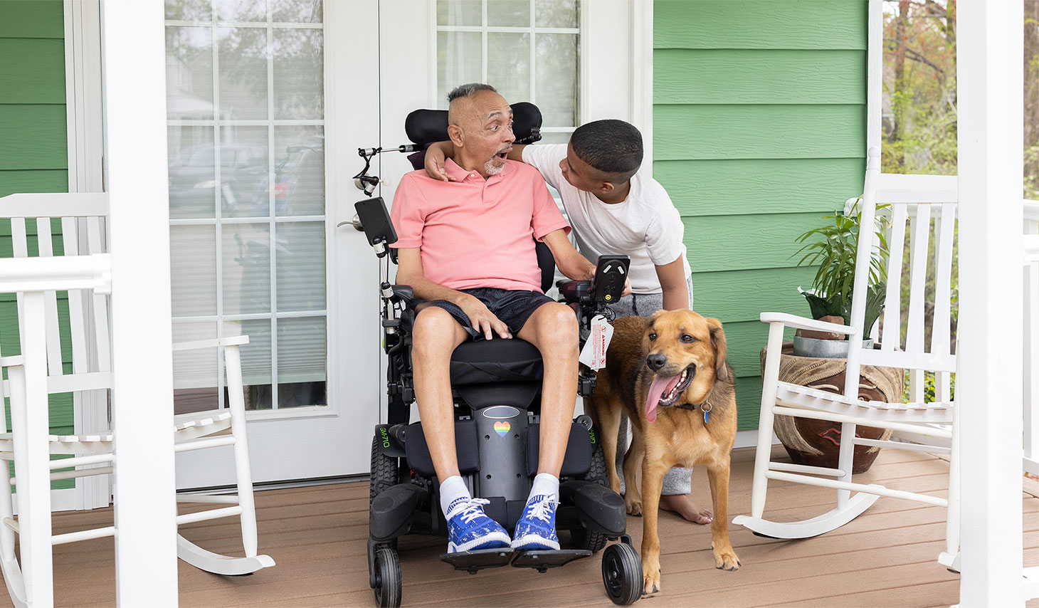 ALS patient in motorized chair with family member and dog