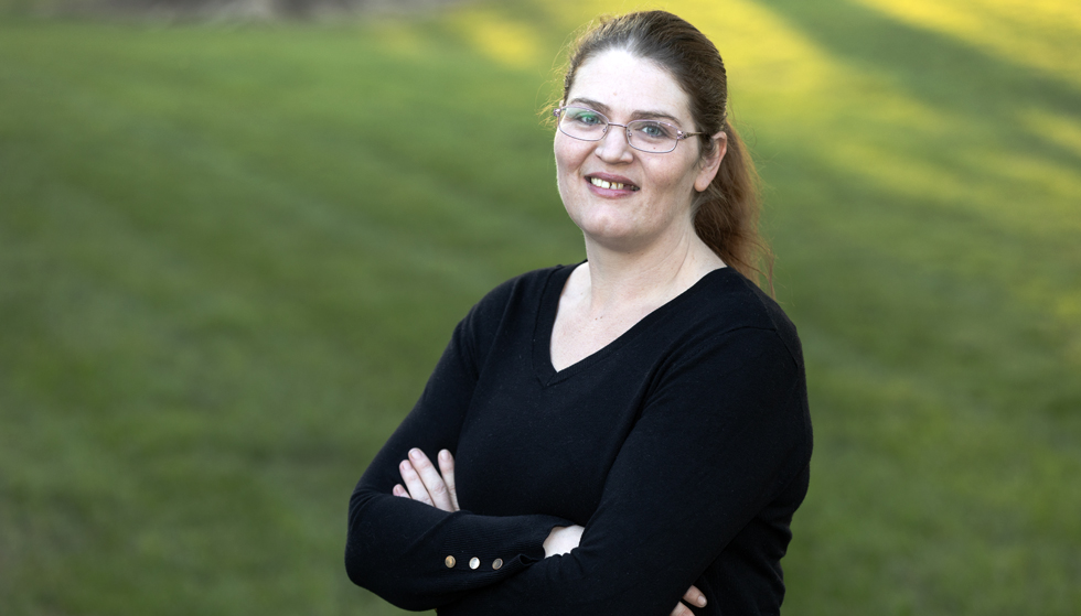 Maggie, a woman living with PBH, smiling in a park
