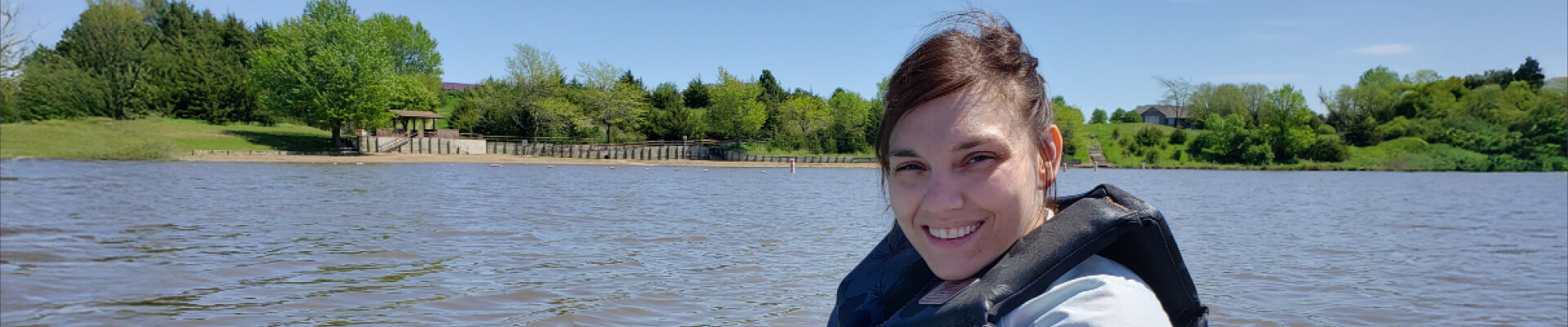 Woman sitting in a kayak on a nice day on a lake
