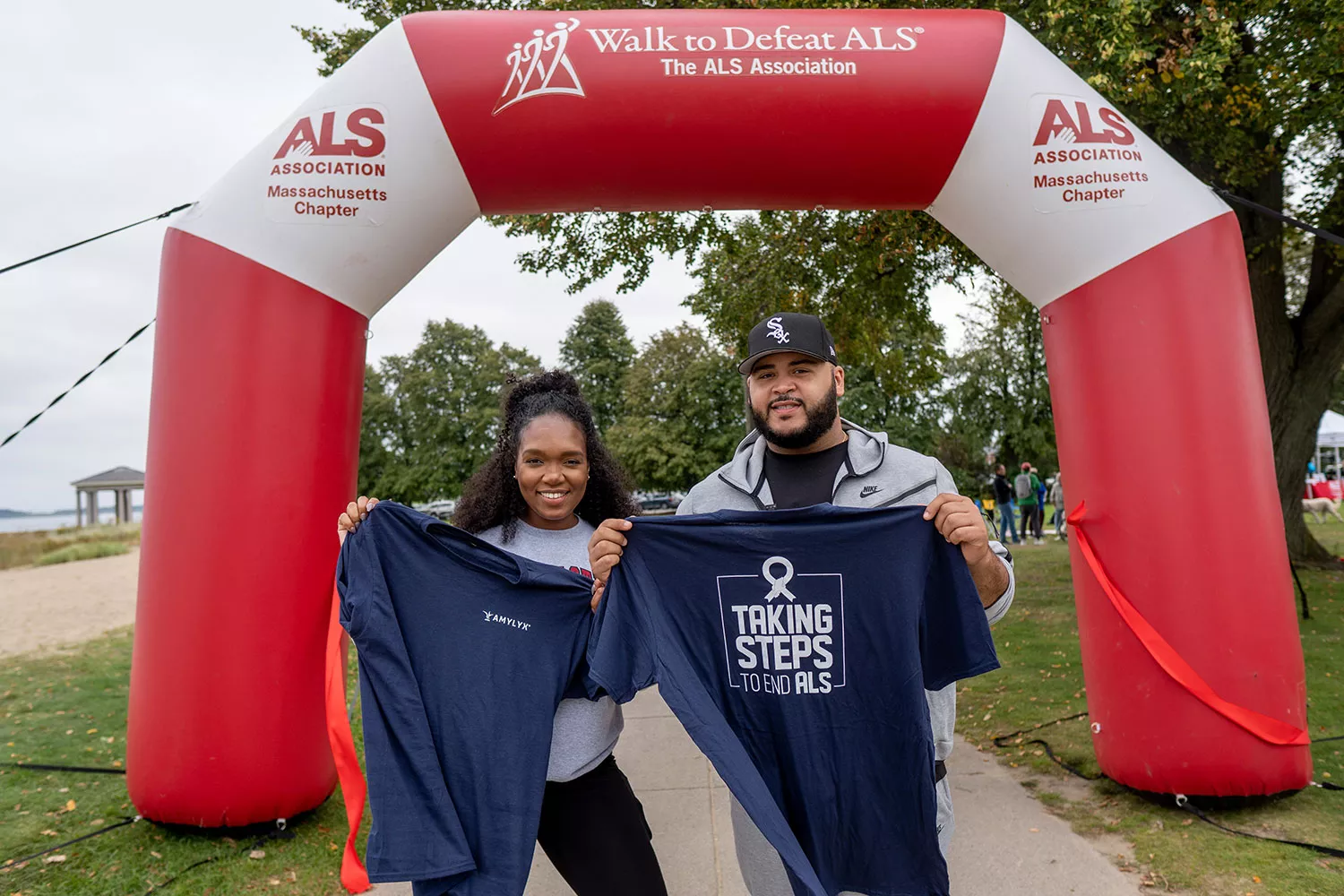 Amylyx employees holding up their team shirts at an ALS walk 